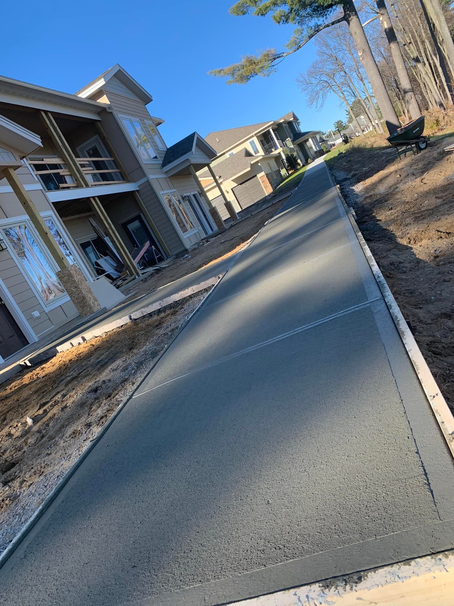 Sloped concrete walkway beside apartment buildings under a clear blue sky