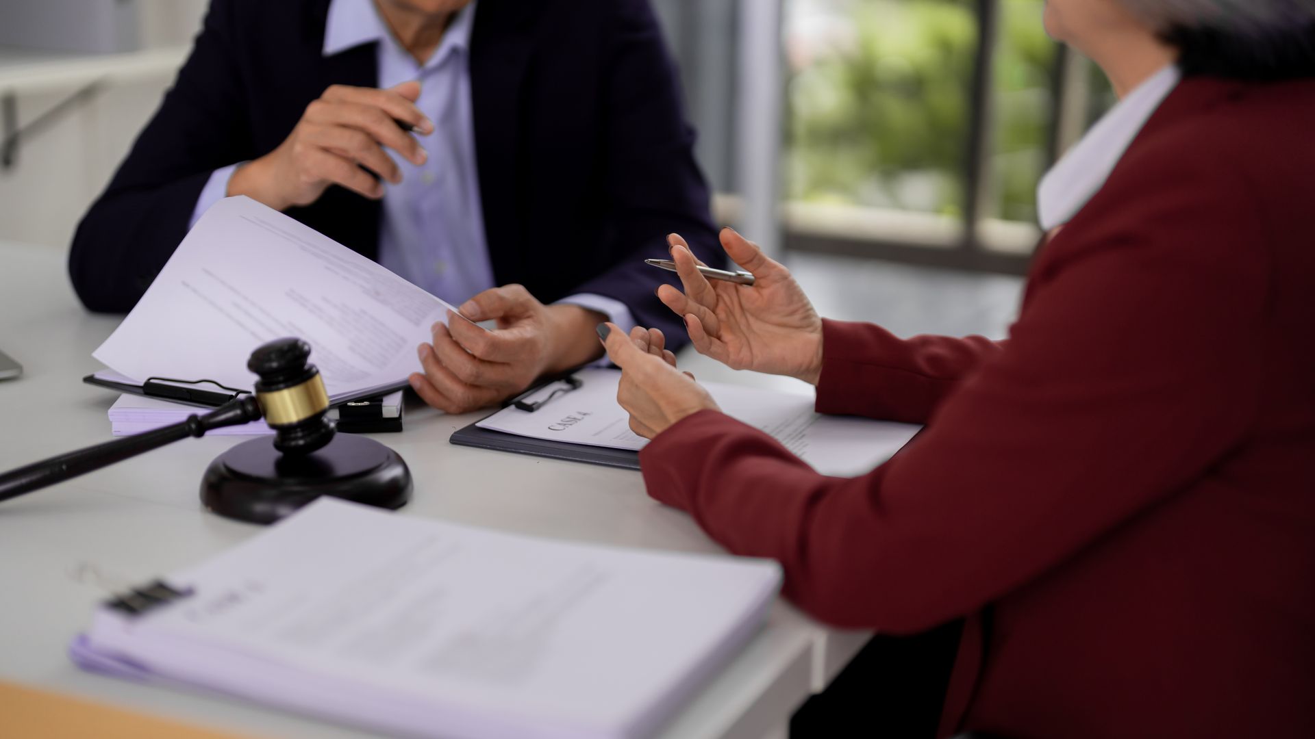 A trusts attorney reviewing legal documents during a private client consultation in an office. A trusts attorney reviewing legal documents during a private client consultation in an office.