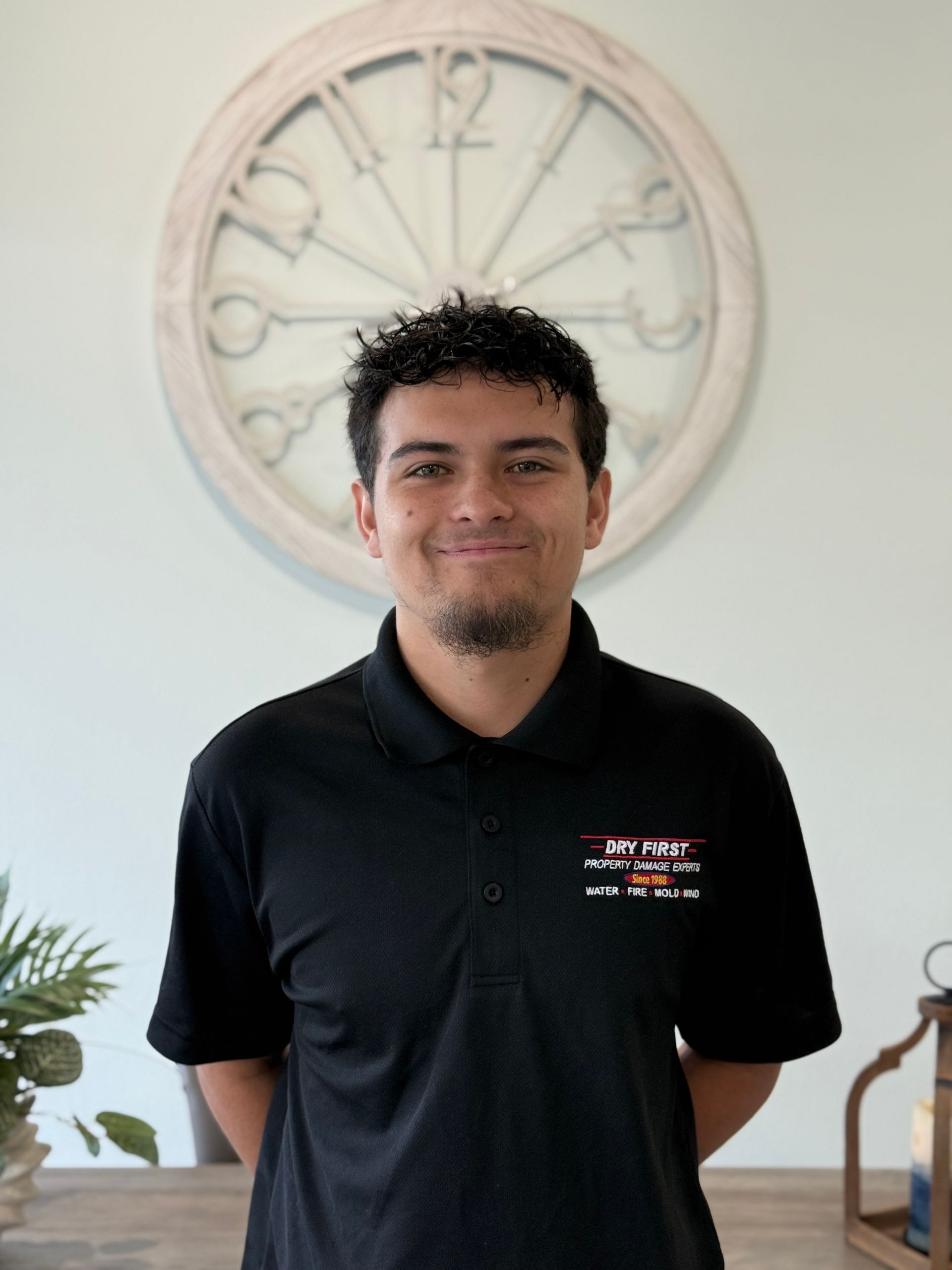 A team member of dryfirst restoration company standing and smilinn