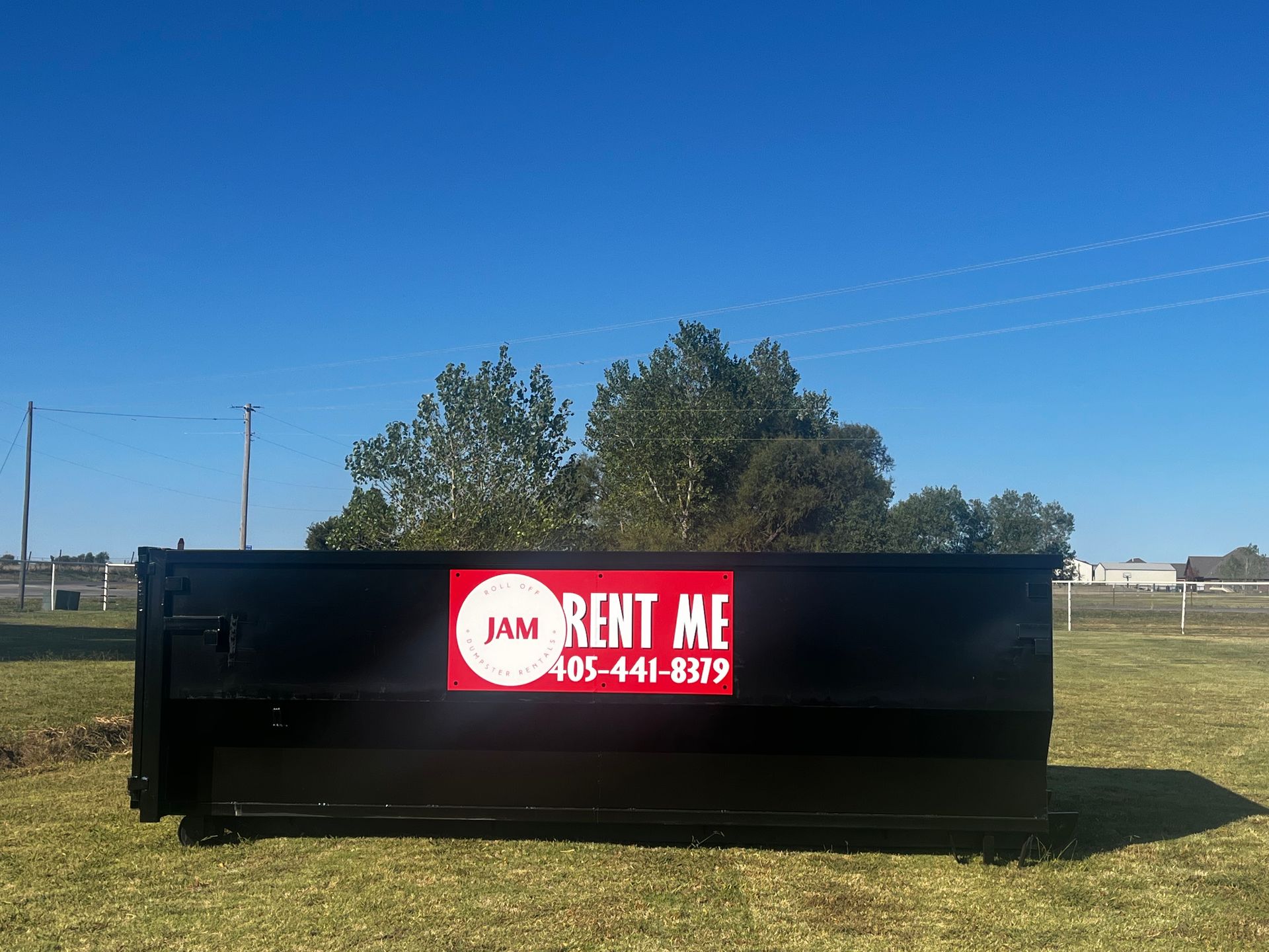 Black dumpster with a red 