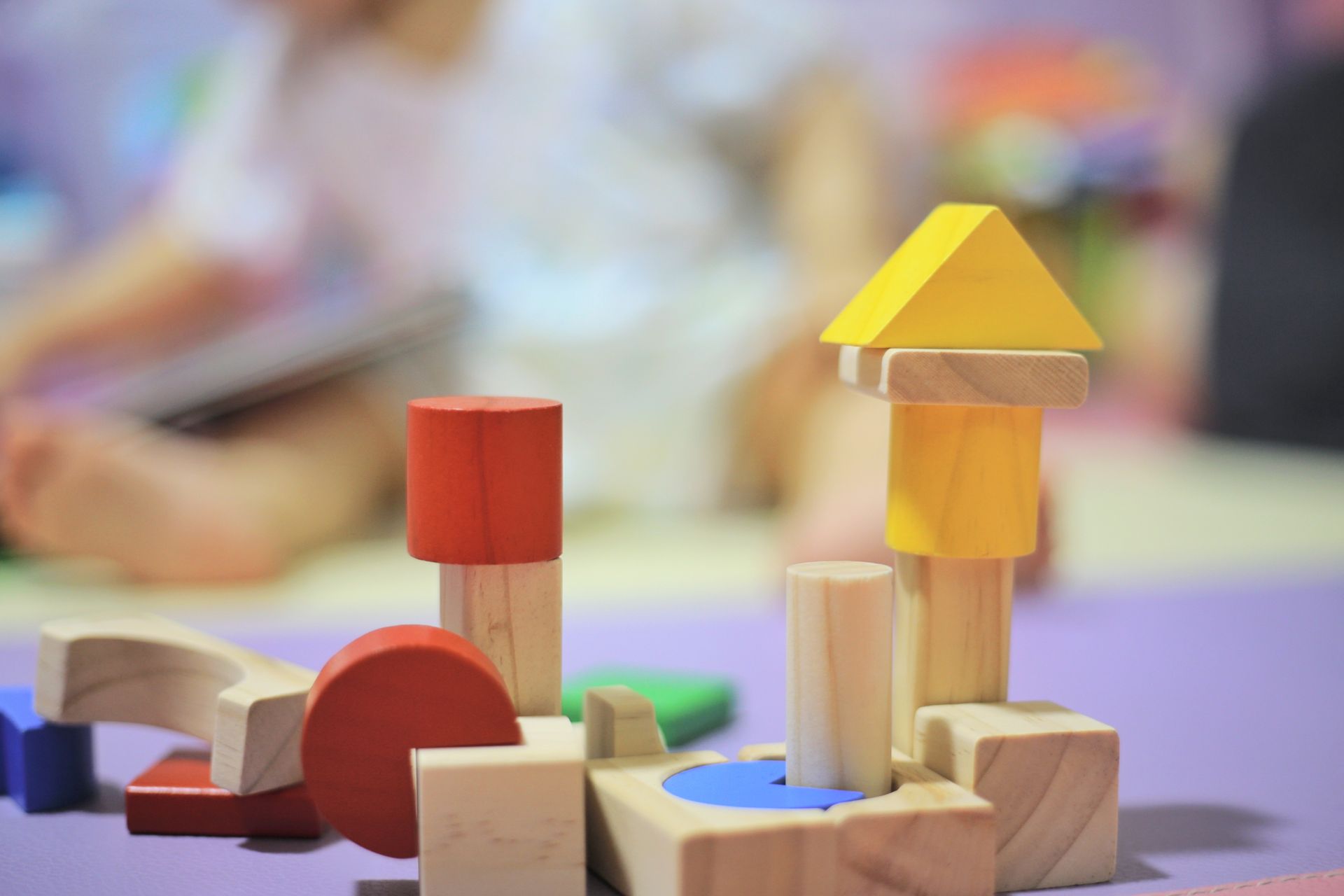 Un bambino sta giocando con dei blocchi di legno su un tavolo.