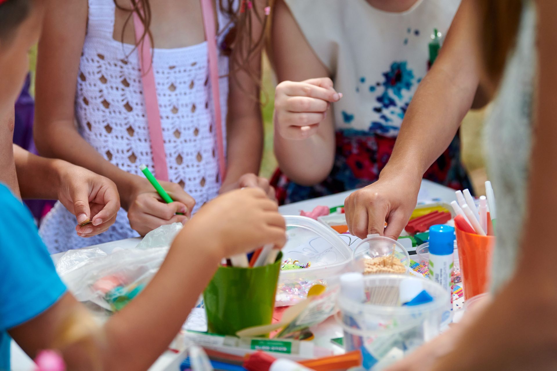 Un gruppo di bambini è seduto a un tavolo e gioca con i pennarelli.