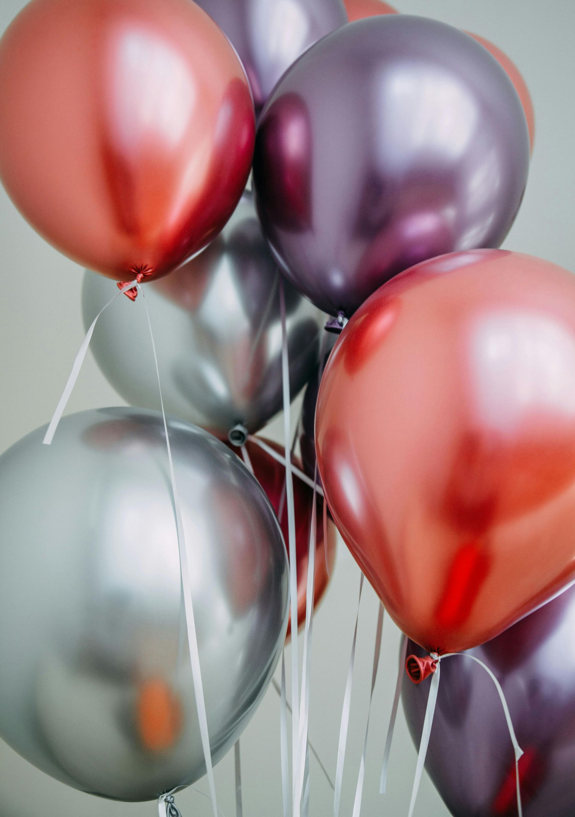 Un mazzo di palloncini rossi, viola e argento appesi a fili
