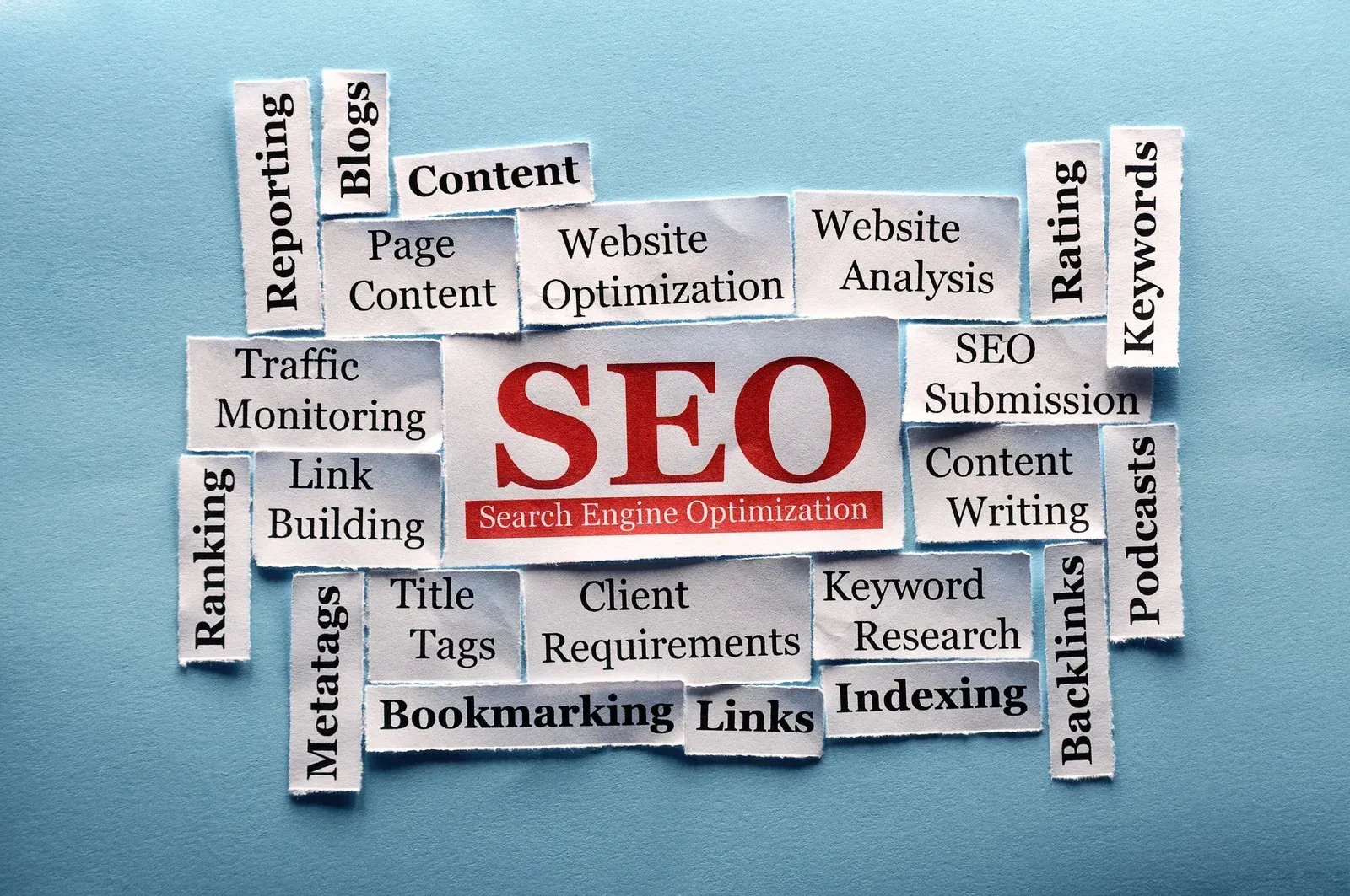 Words related to SEO, cut from paper, arranged around the word