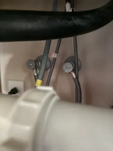 Close-up of black and gray cables connected to metal mounts inside a machine