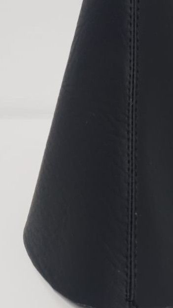 Objeto negro en forma de cono sobre un fondo claro.