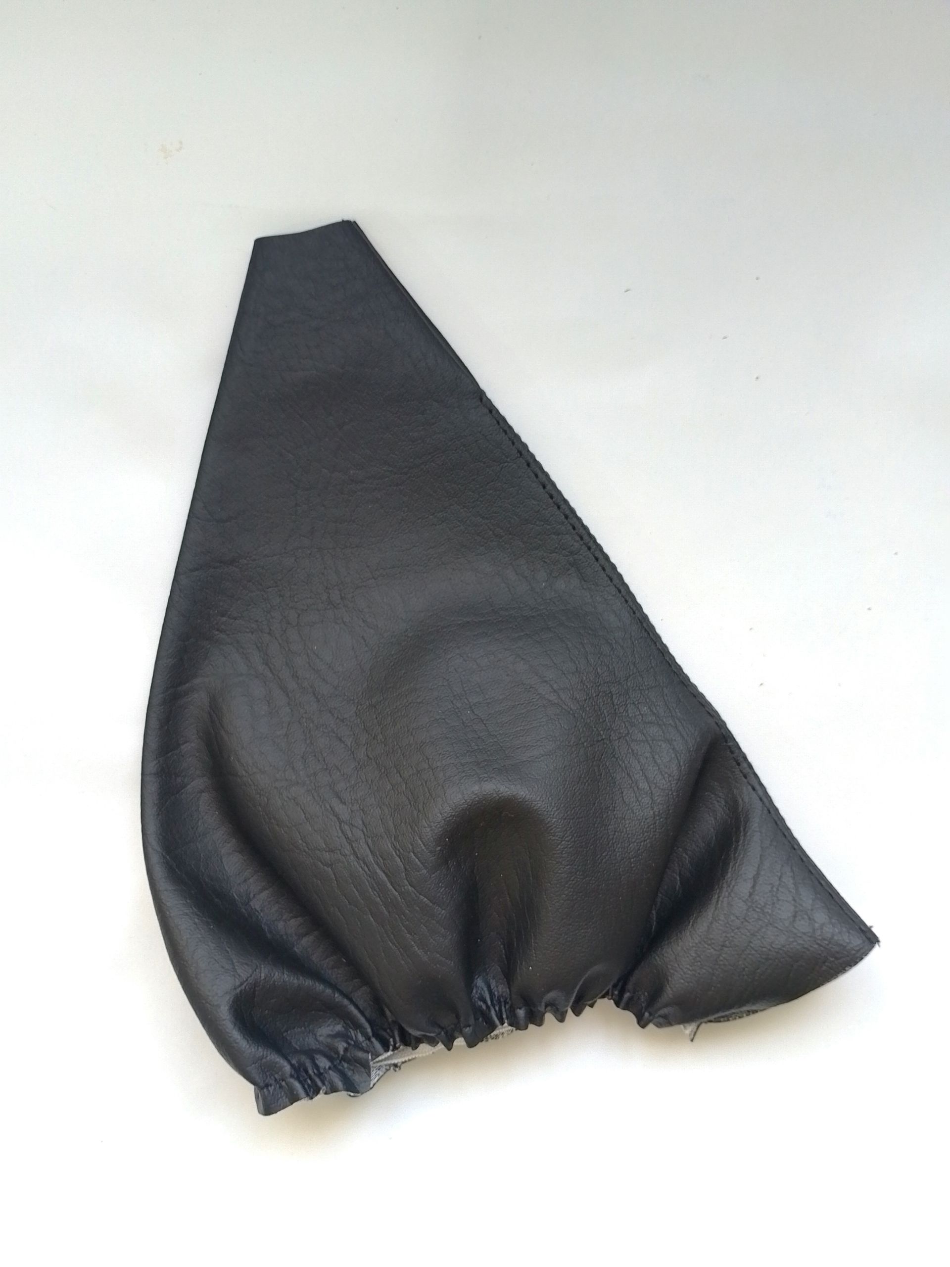 Funda de palanca de cambios de cuero negro con dos anillos cromados y pomo de palanca de cambios negro sobre fondo blanco.