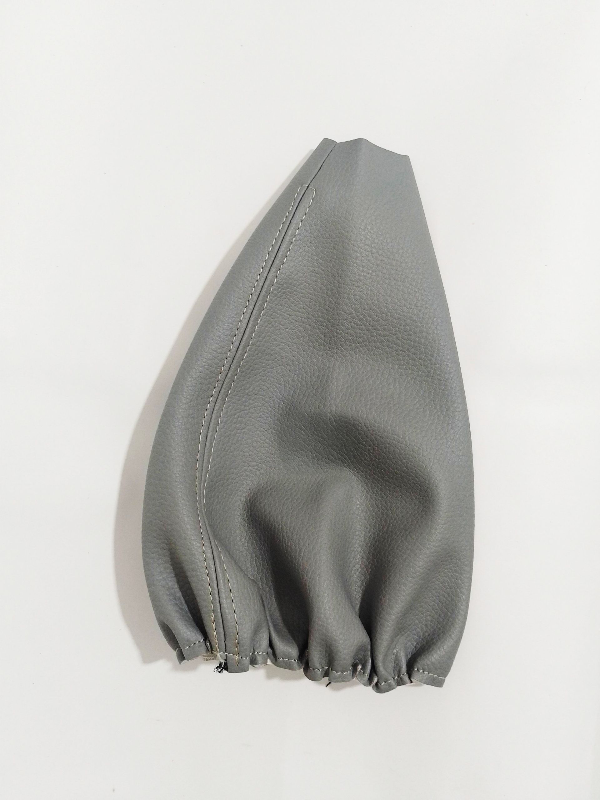 Funda de tela gris para cono colocada en posición vertical sobre un fondo blanco.