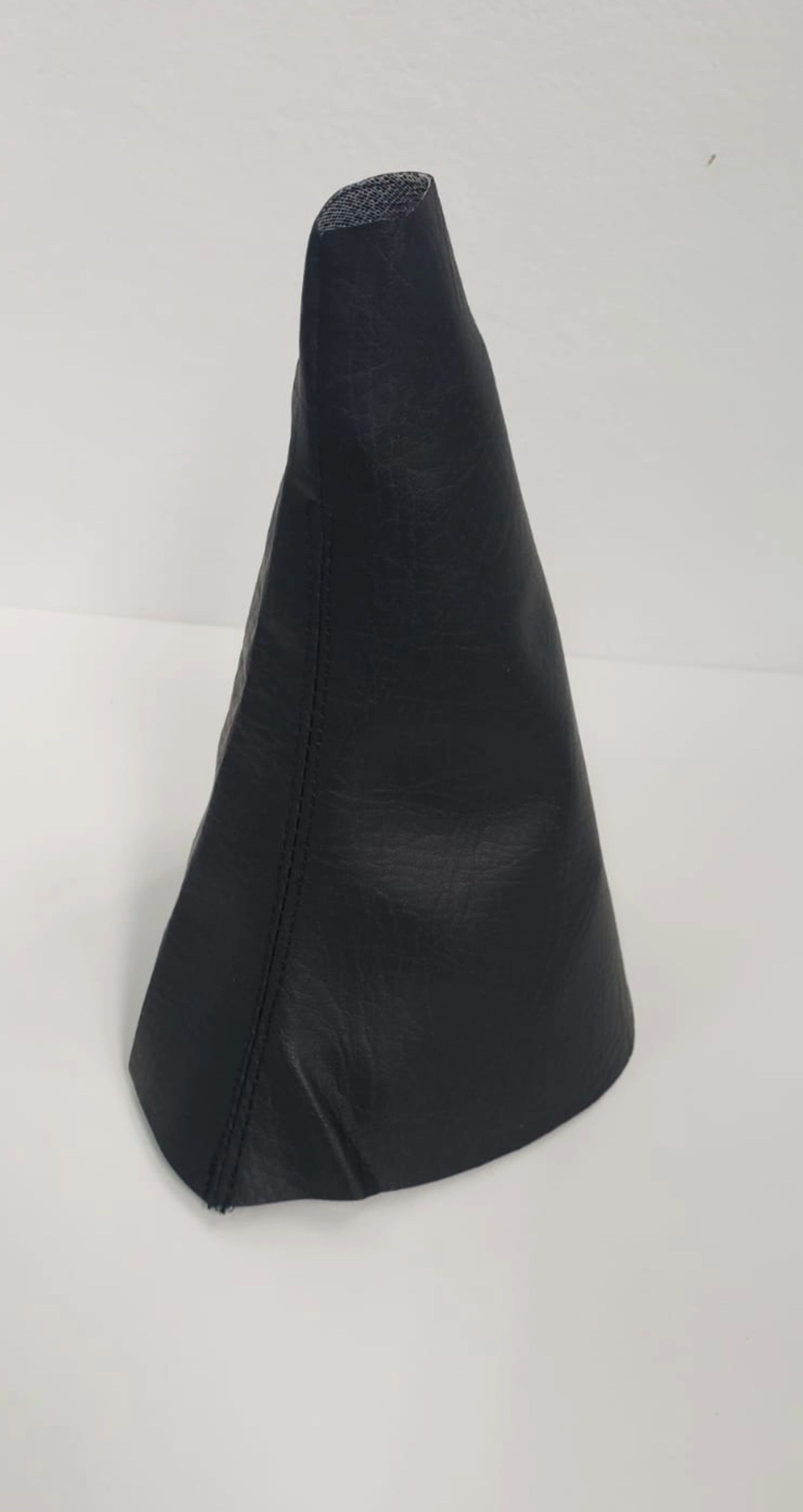 Cubierta de tela negra en forma de cono sobre un fondo liso claro.