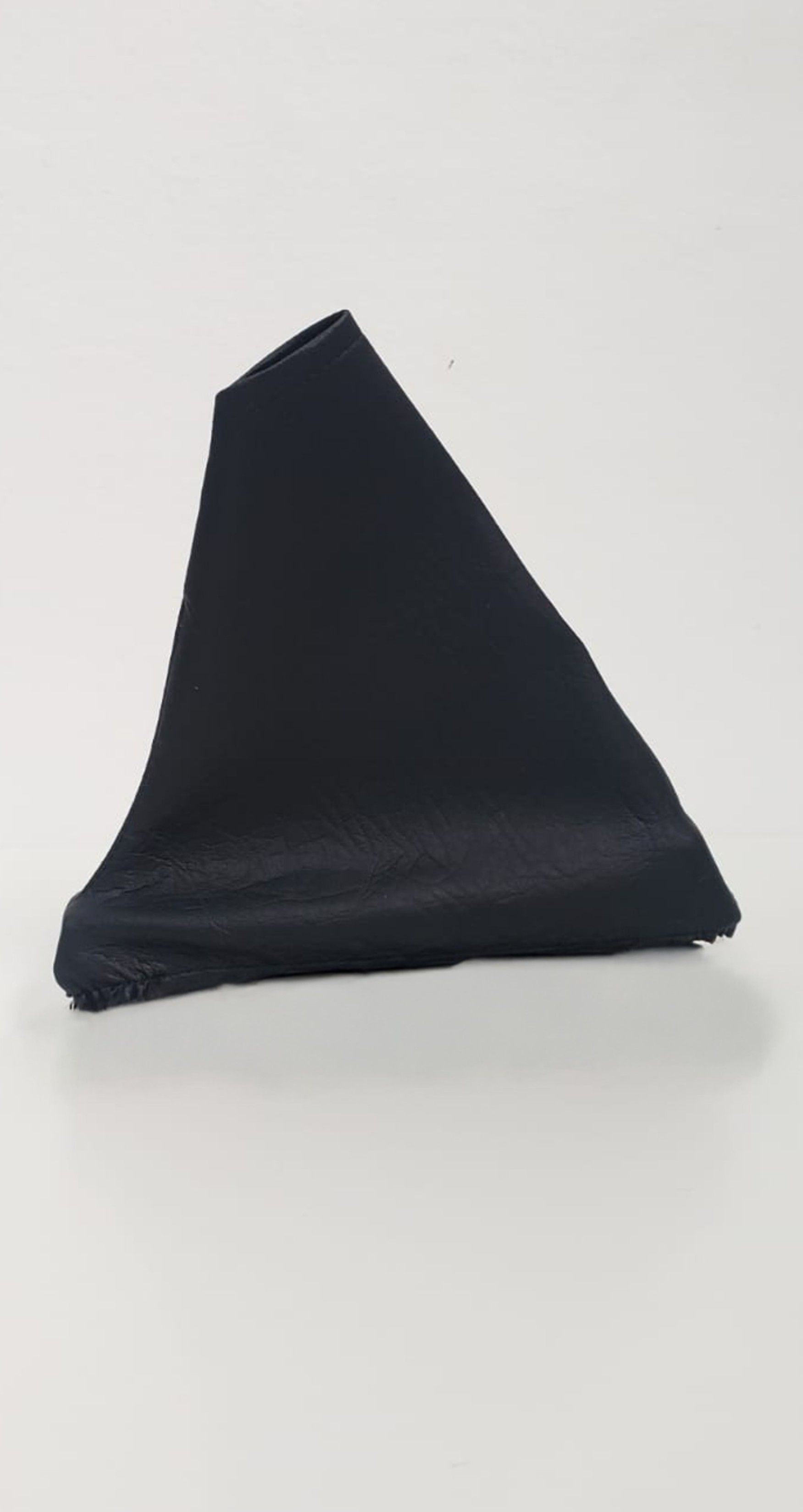 Objeto negro en forma de cono sobre un fondo claro.