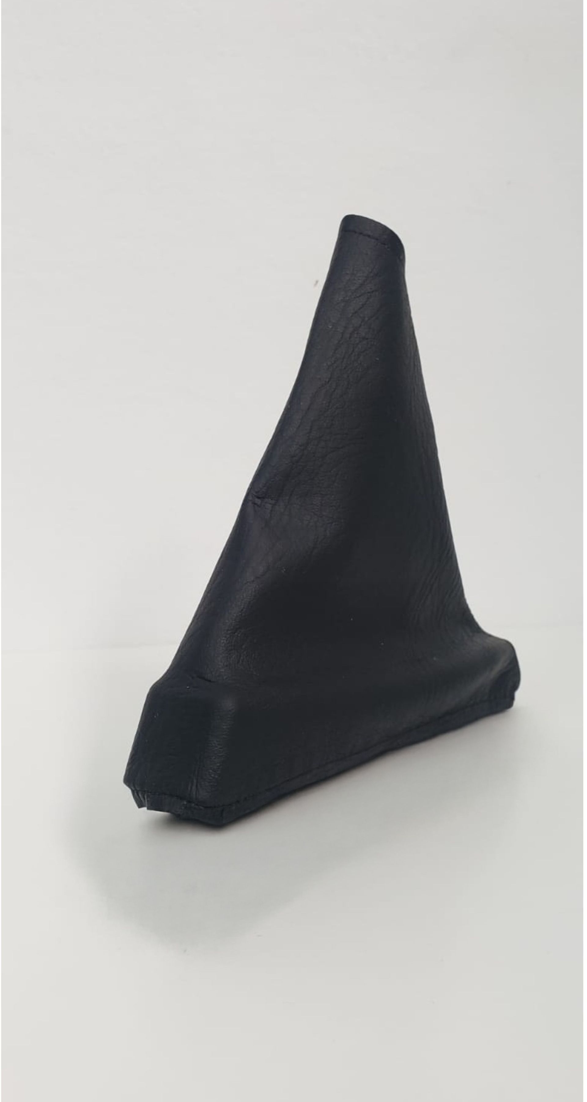 Objeto negro en forma de cono sobre un fondo claro.