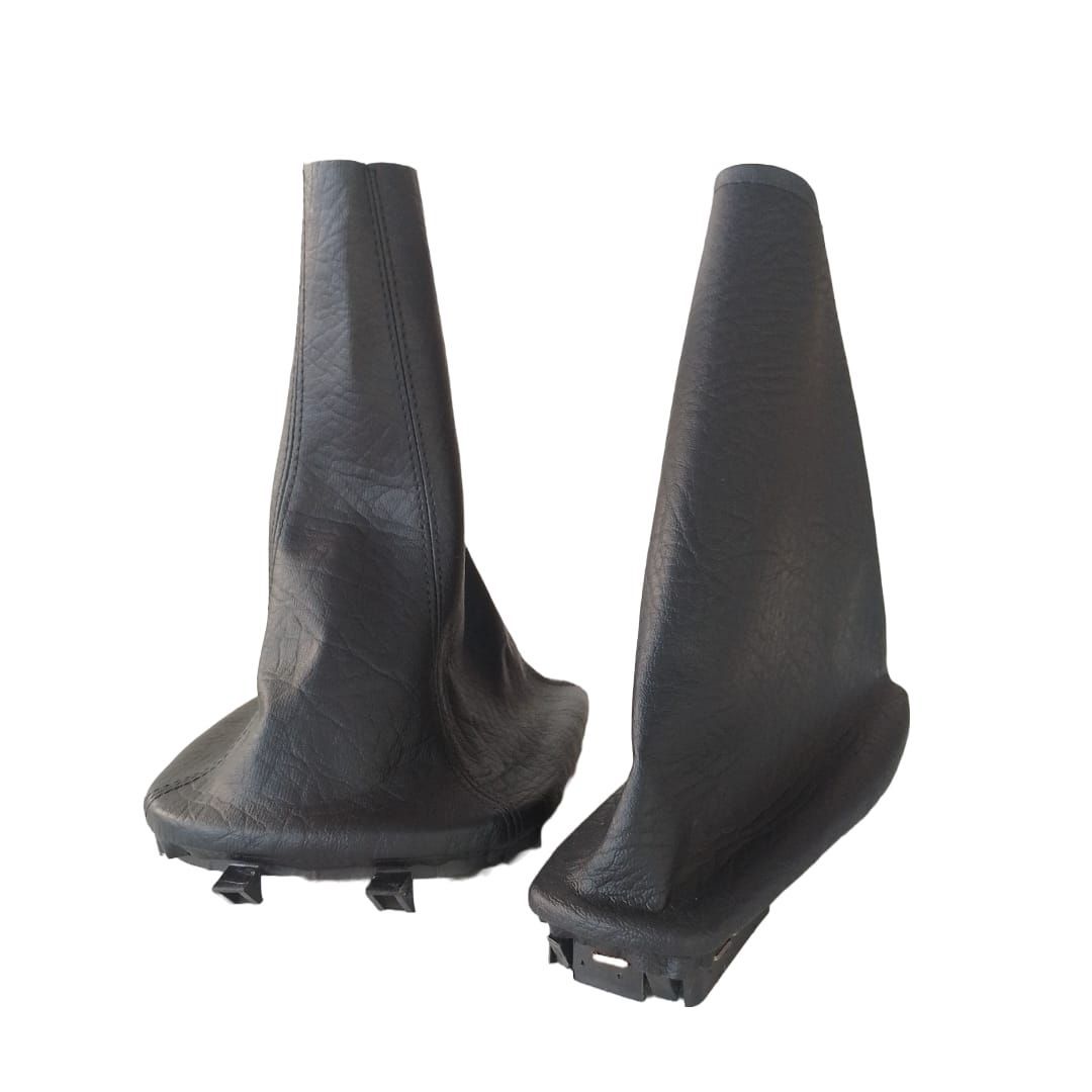 Dos fundas negras para la palanca de cambios manual con soportes de base sobre un fondo blanco.