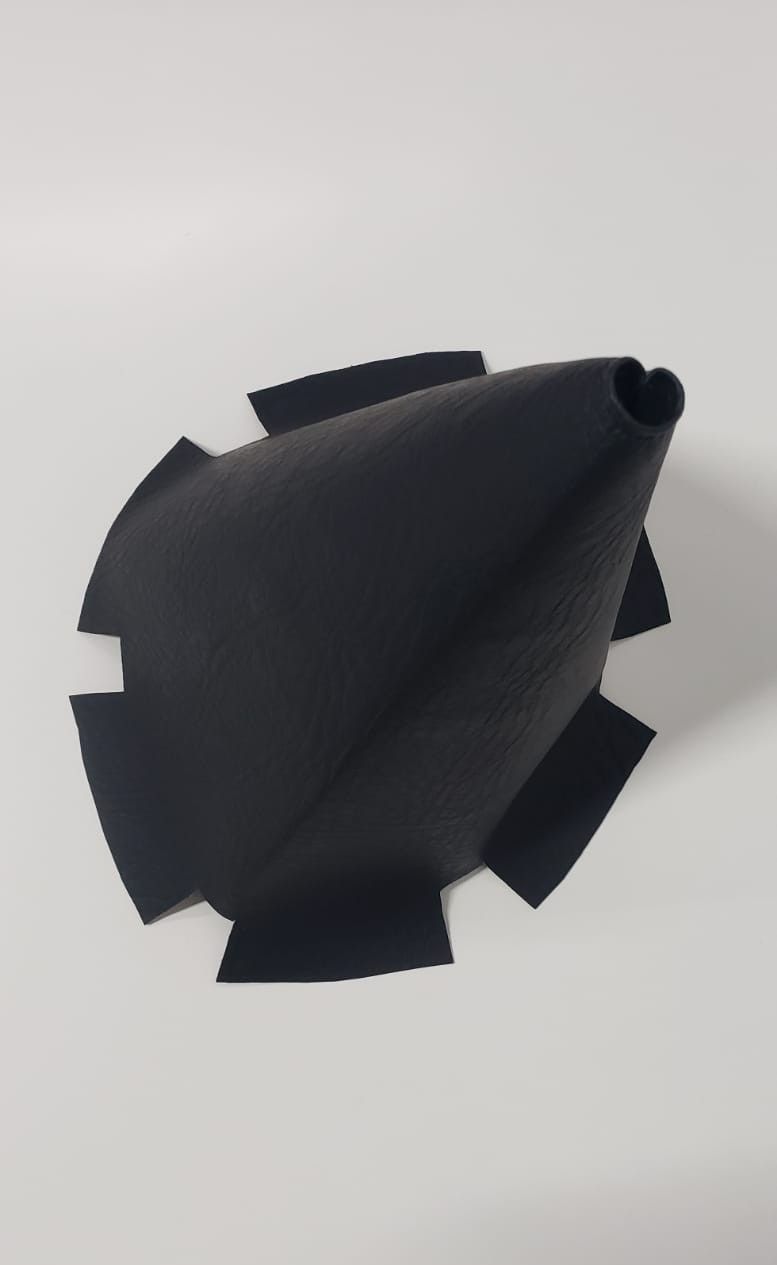 Funda o bolsa triangular de tela negra colocada en posición vertical sobre un fondo claro.