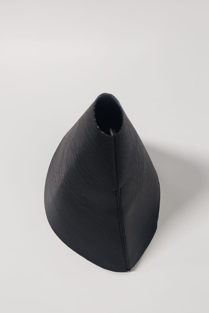 Objeto negro en forma de cono sobre un fondo blanco.