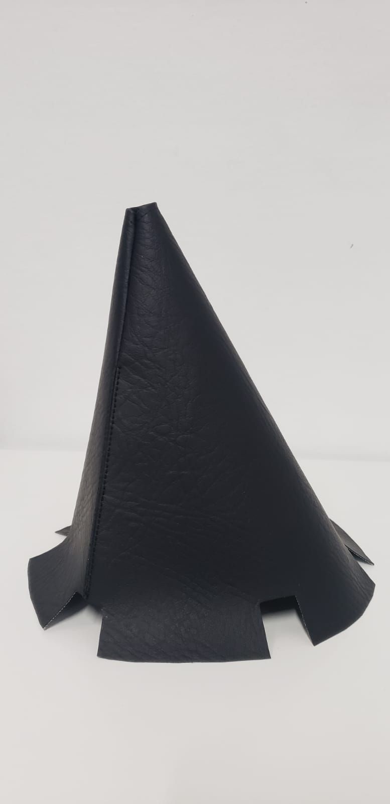 Funda o bolsa triangular de tela negra colocada en posición vertical sobre un fondo claro.