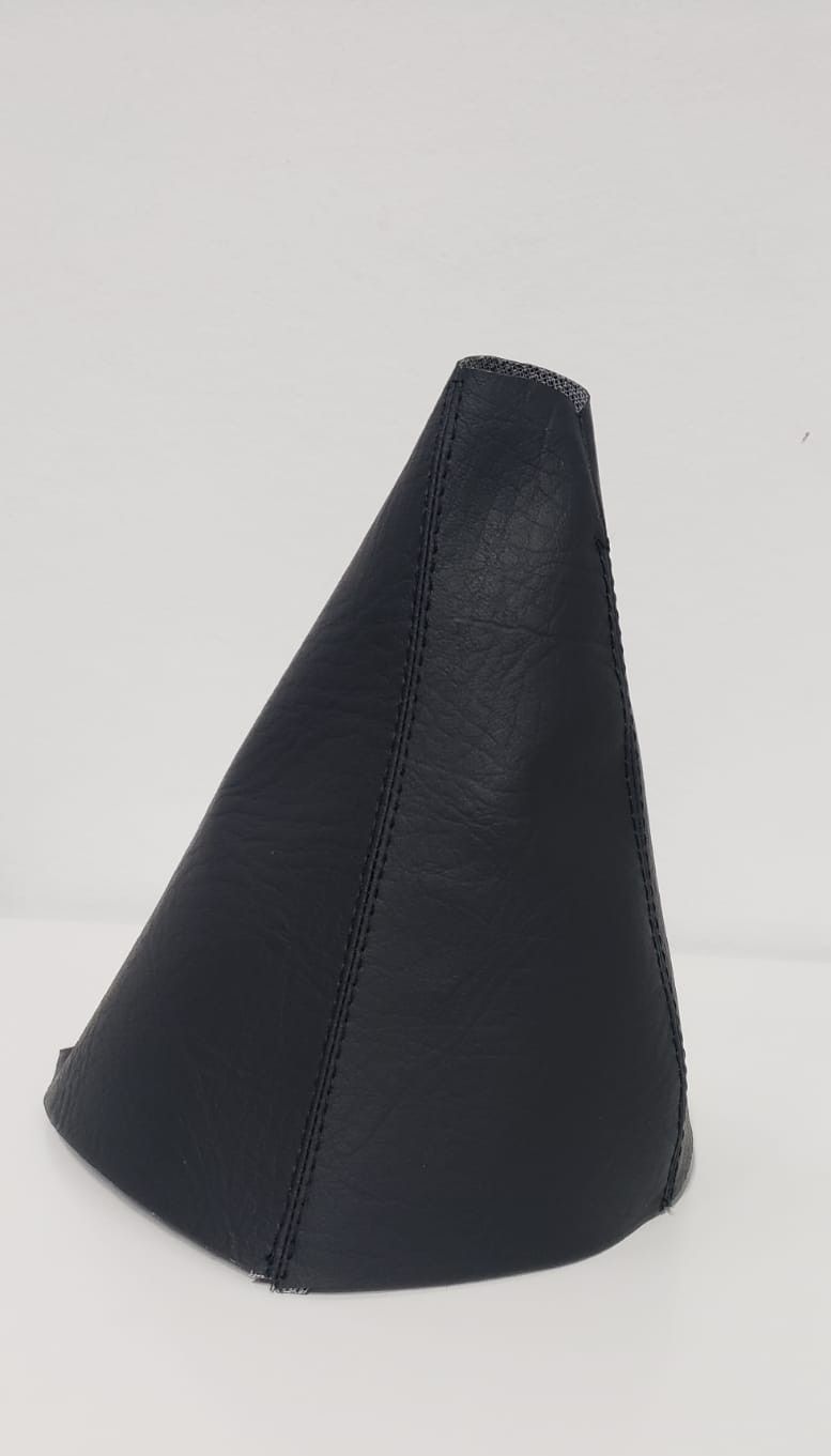 Artesanía negra en forma de cono con costuras cosidas sobre un fondo blanco.
