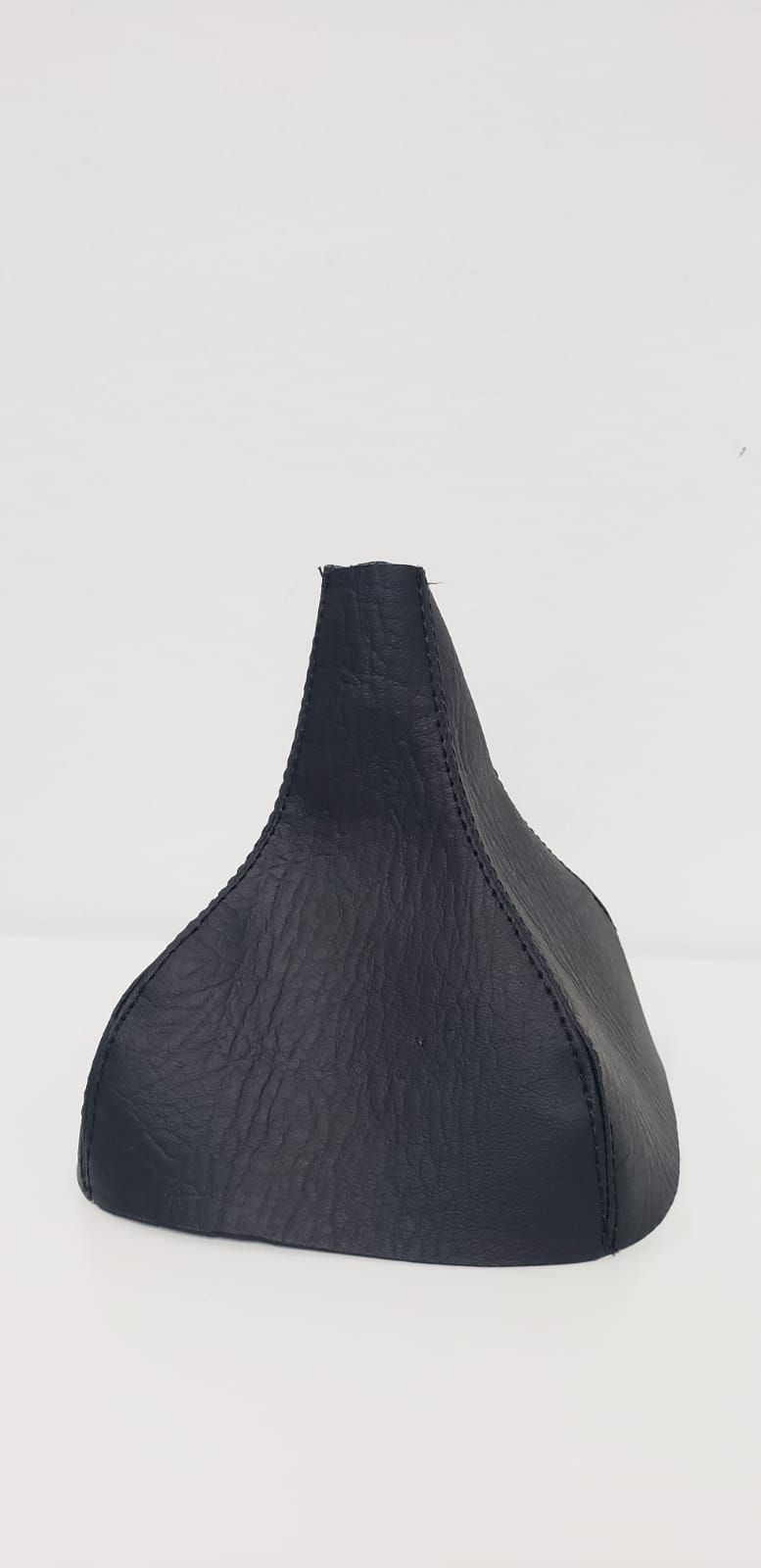 Objeto negro texturizado en forma de cono sobre un fondo blanco.