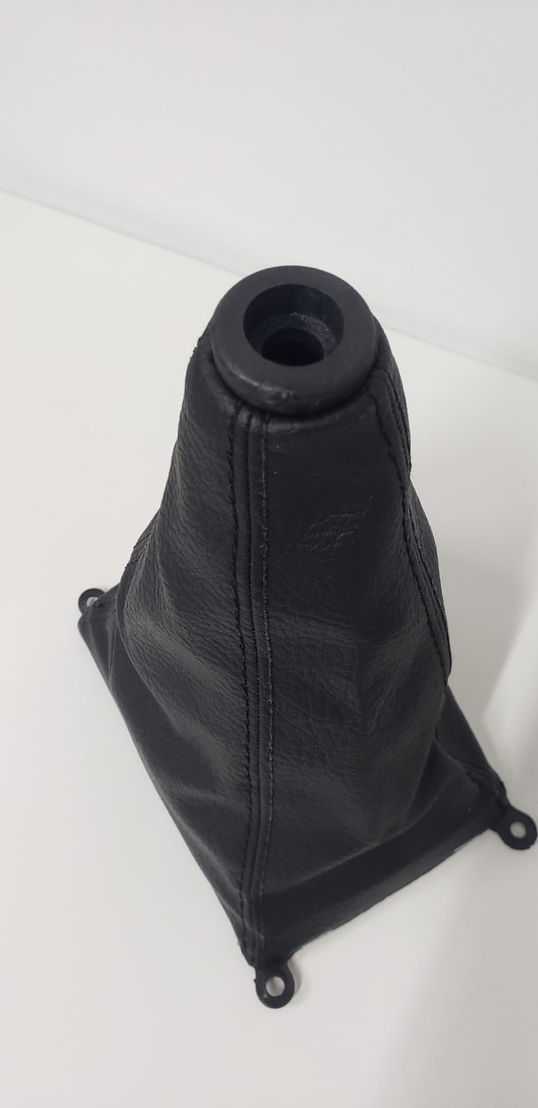 Bolsa de viaje de malla negra colocada en posición vertical sobre un fondo blanco.