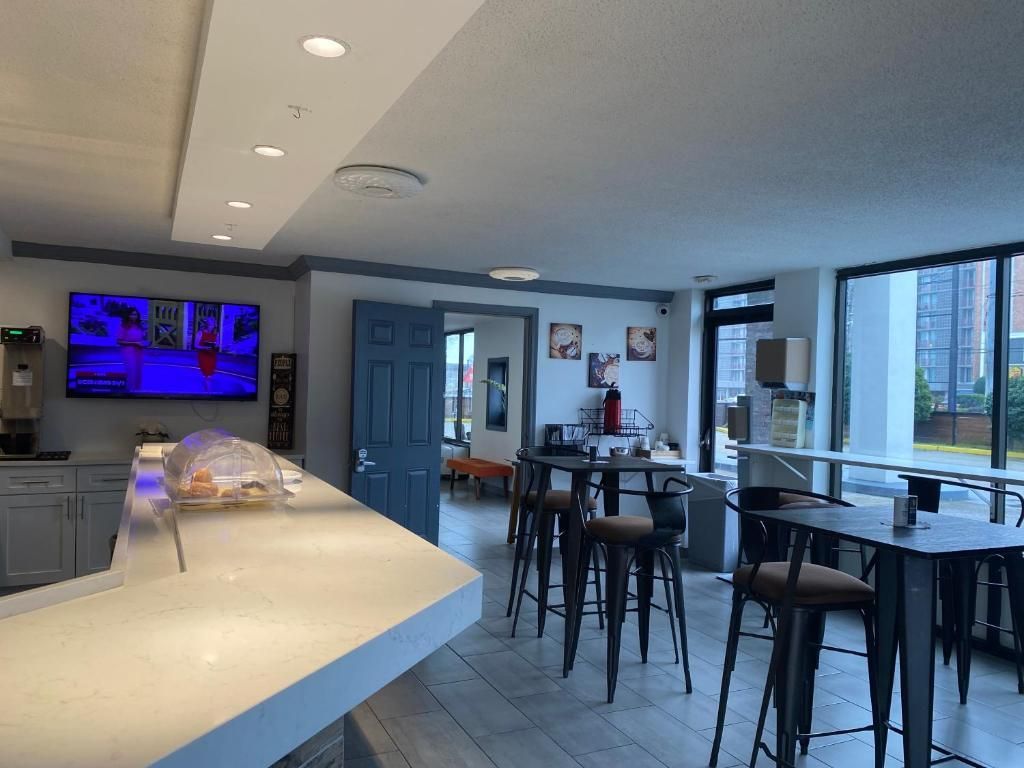 Bar area with a counter, tables, and a large TV. Blue door visible.