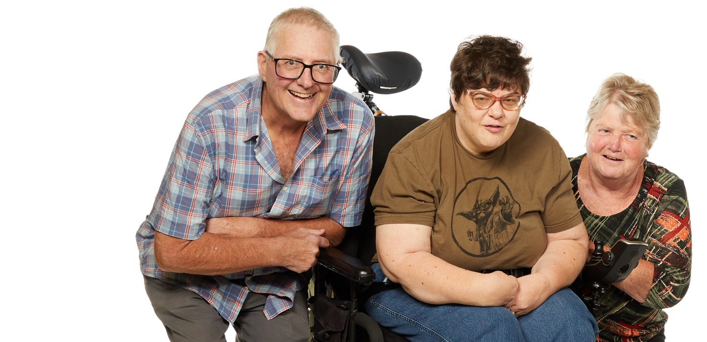 A man and a woman are sitting next to a boy in a wheelchair.