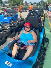 a woman is sitting in a blue go kart