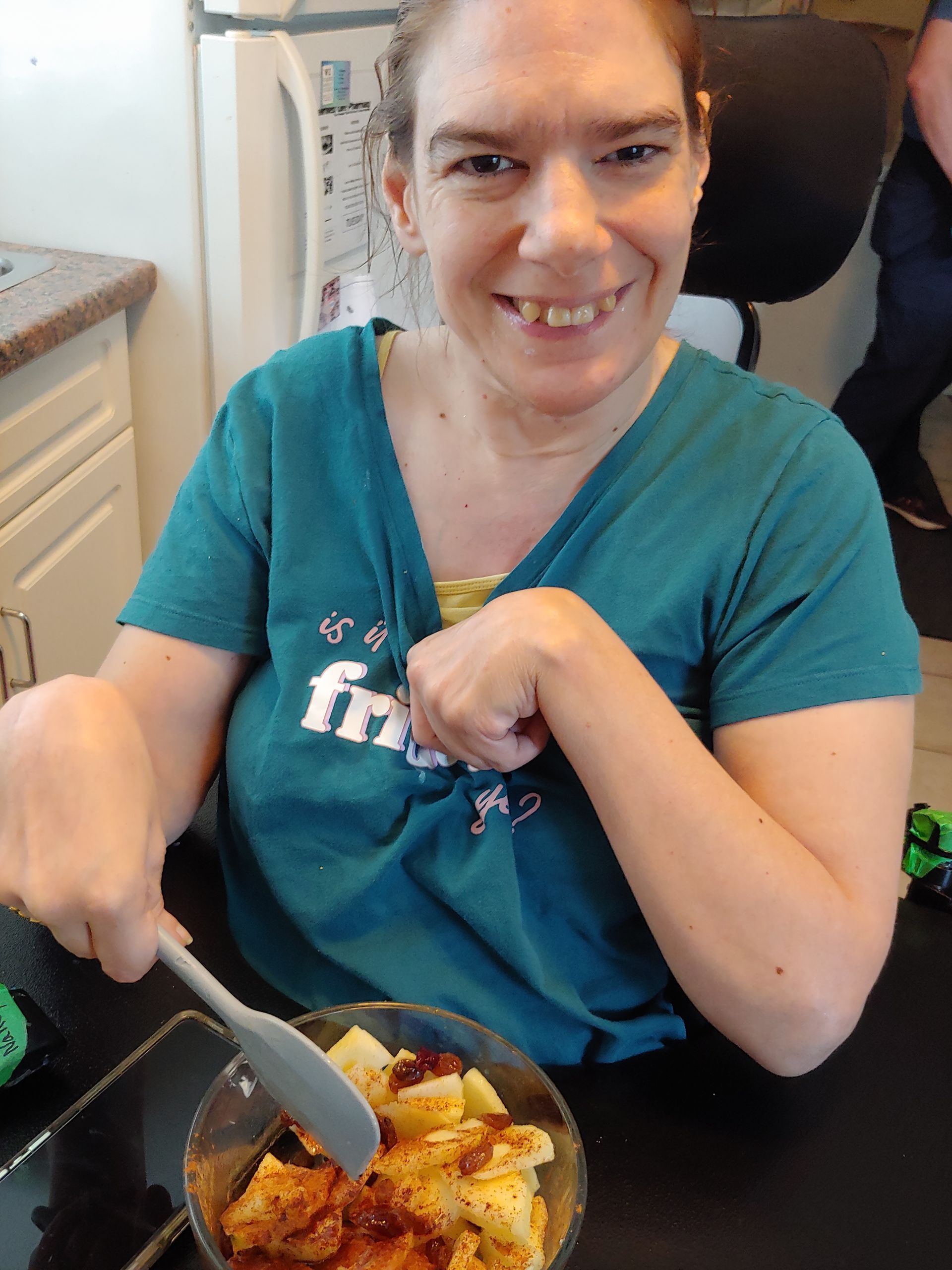 A woman in a blue shirt with the word friends on it is eating food