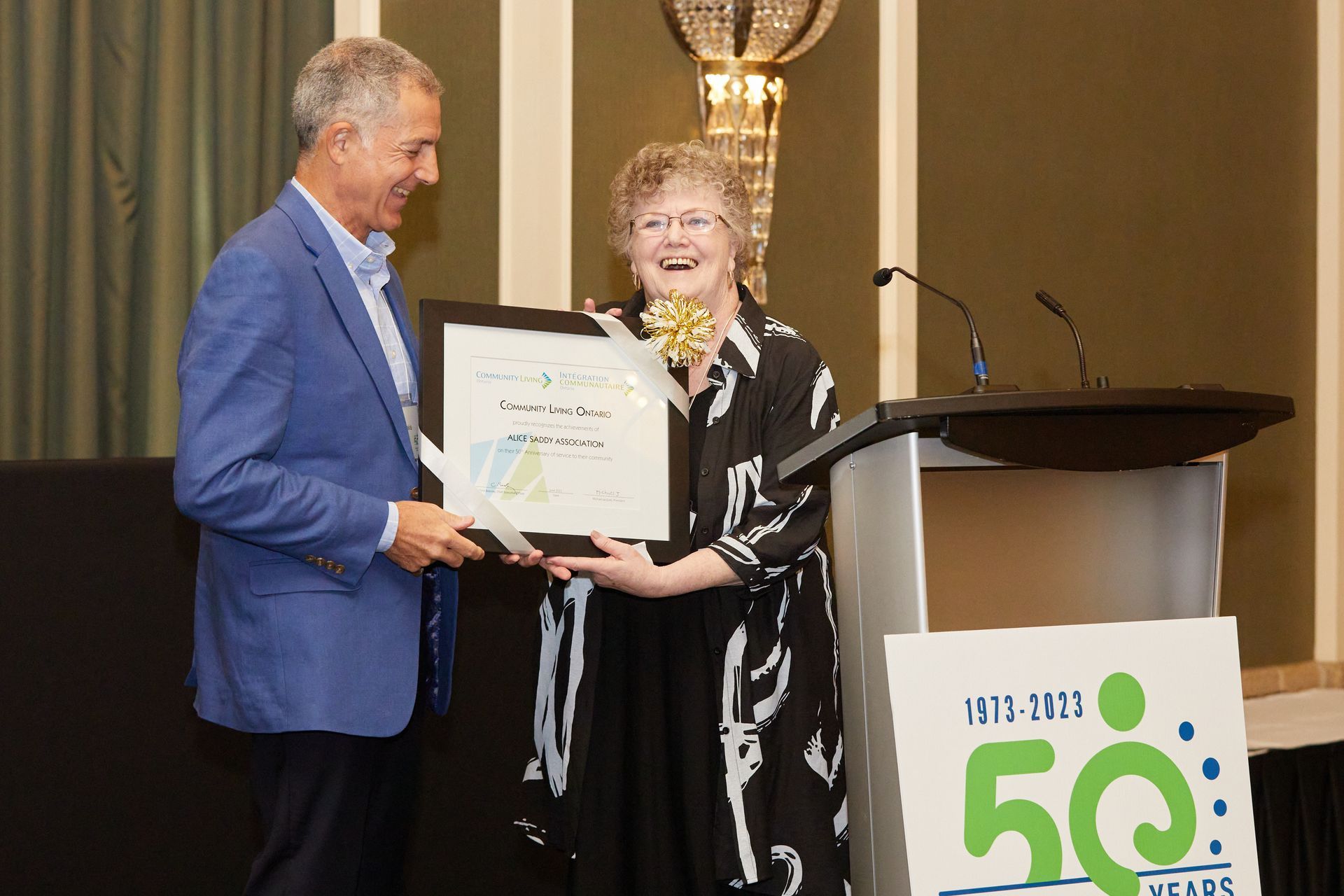 a man is giving a certificate to a woman at a podium .