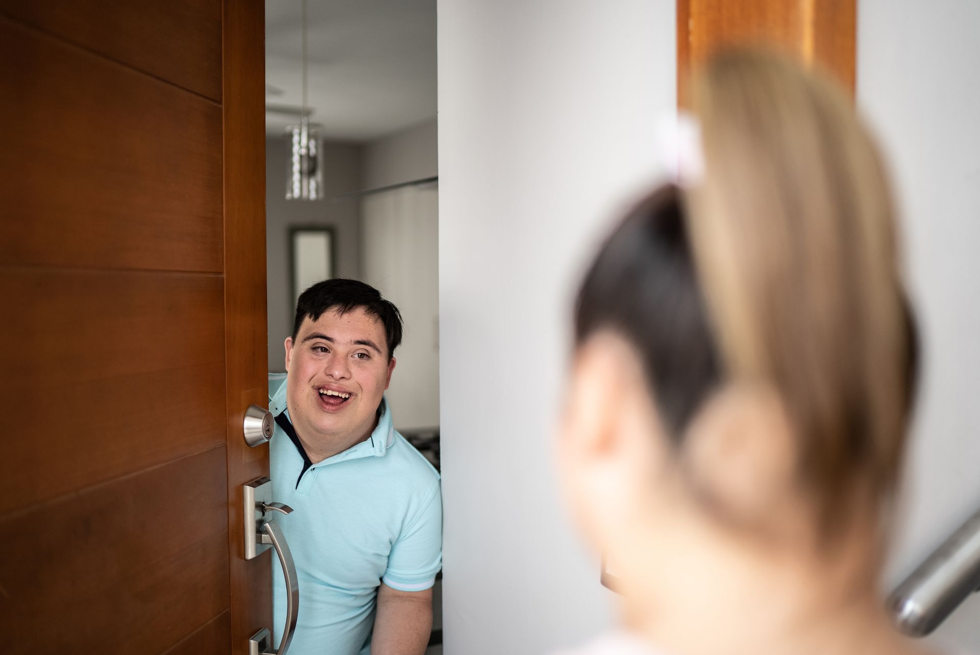 A male opening door and speaking with a woman
