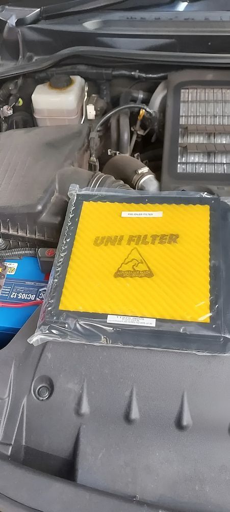 A Yellow Filter Is Sitting Under The Hood Of A Car — A & D Automotive Technicians in Mackay, QLD