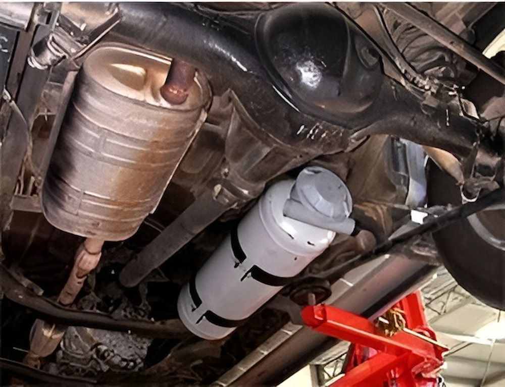 The Underside Of A Car Being Lifted By A Red Jack — A & D Automotive Technicians in Mackay, QLD