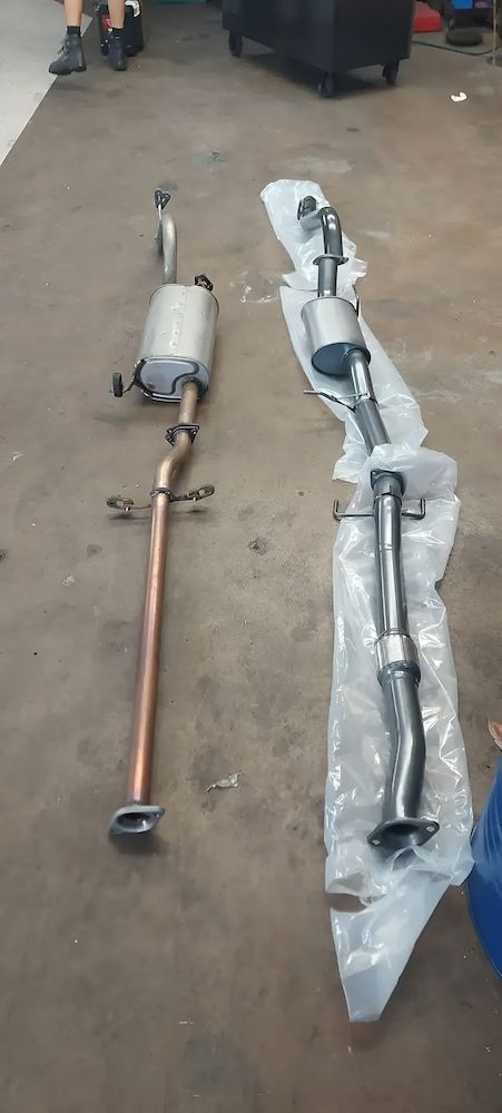 A Couple Of Exhaust Pipes Sitting On Top Of A Concrete Floor — A & D Automotive Technicians in Mackay, QLD