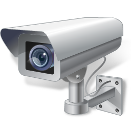 Security camera mounted on a wall; gray, watching.