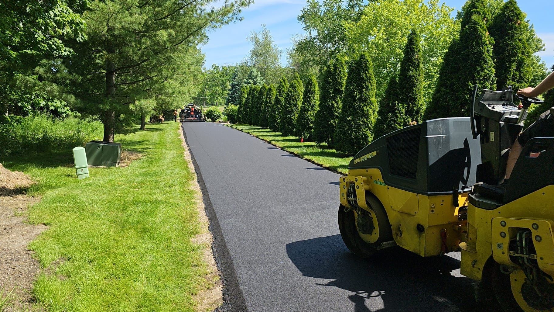 Freshly paved asphalt driveway with Black Earth Pavement compaction equipment