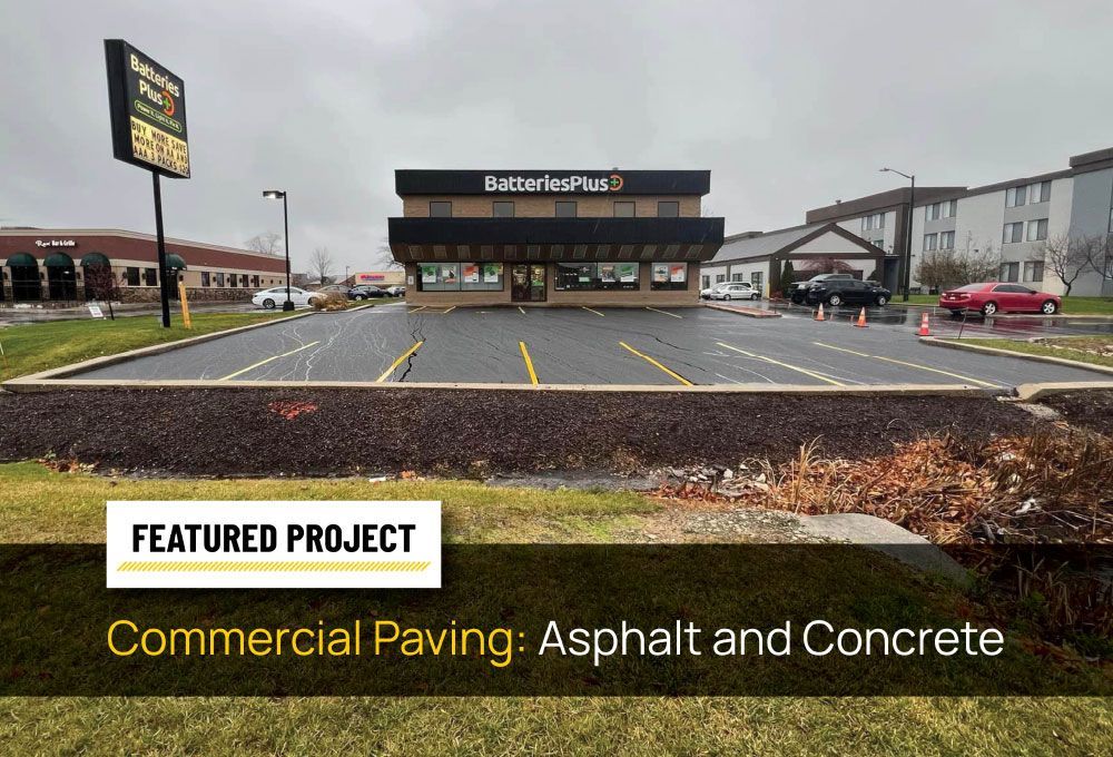 Commercial paving project at a Batteries Plus storefront with fresh asphalt and concrete.