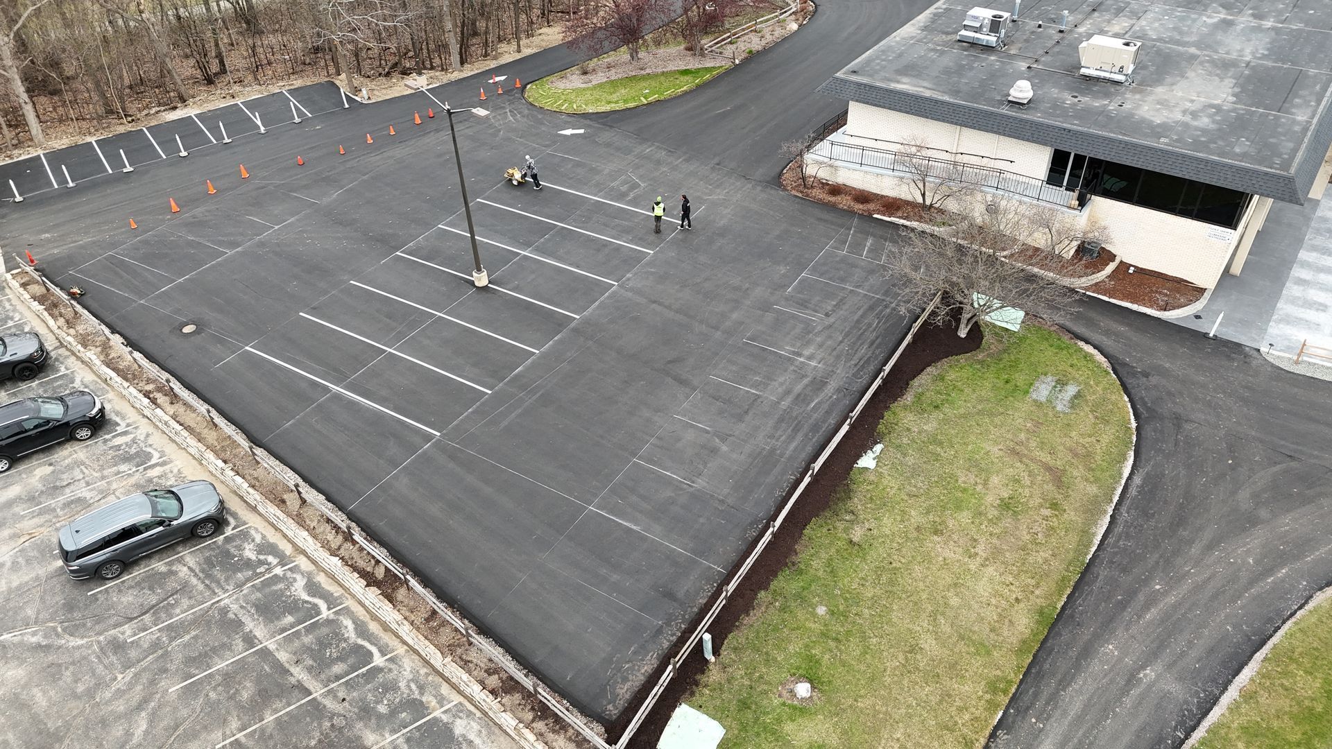 Aerial view of a newly paved commercial parking lot with fresh striping
