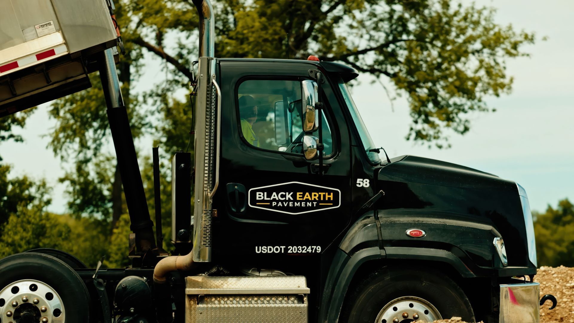 Black Earth Pavement dump truck at an asphalt paving job site