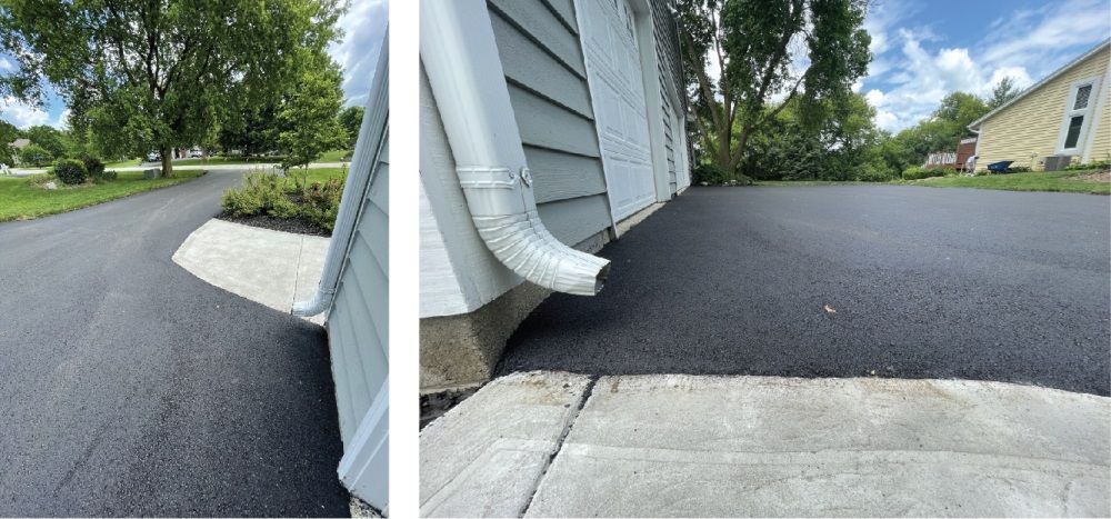Black paving company dump truck parked outdoors with the driver visible inside the cab.