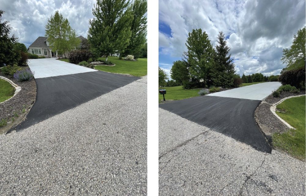 Fresh black asphalt driveway patch beside a gravel drive in a suburban yard under cloudy skies