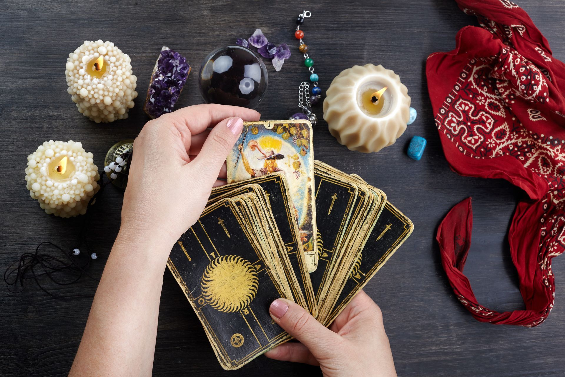 Lady tarot reader pulls a tarot card from the deck.