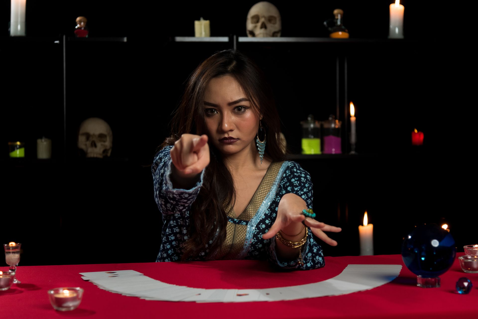 Hands of a woman pointing at a tarot card while reading a fortune to another woman Hands of a woman pointing at a tarot card while reading a fortune to another woman