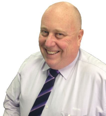 Bald man wearing a light purple shirt and a purple and blue striped tie smiles.