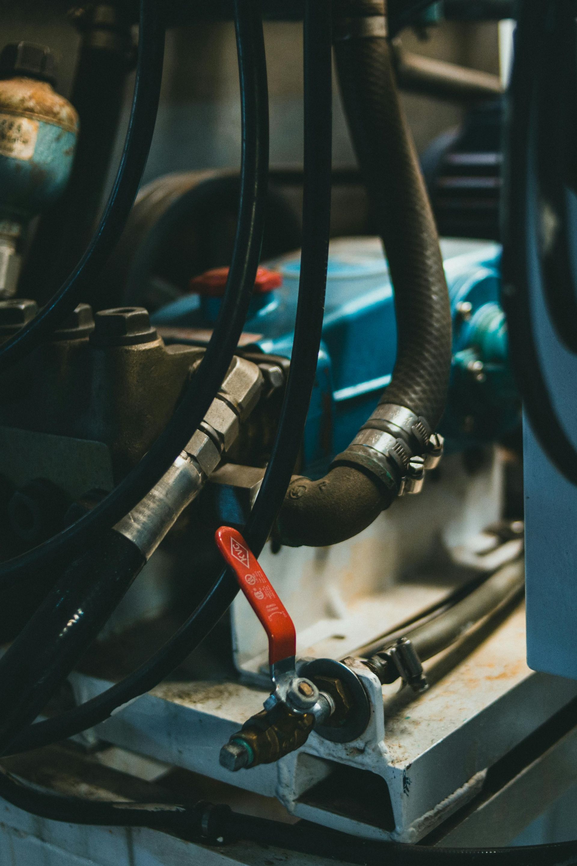 A man is laying under a car in a garage.