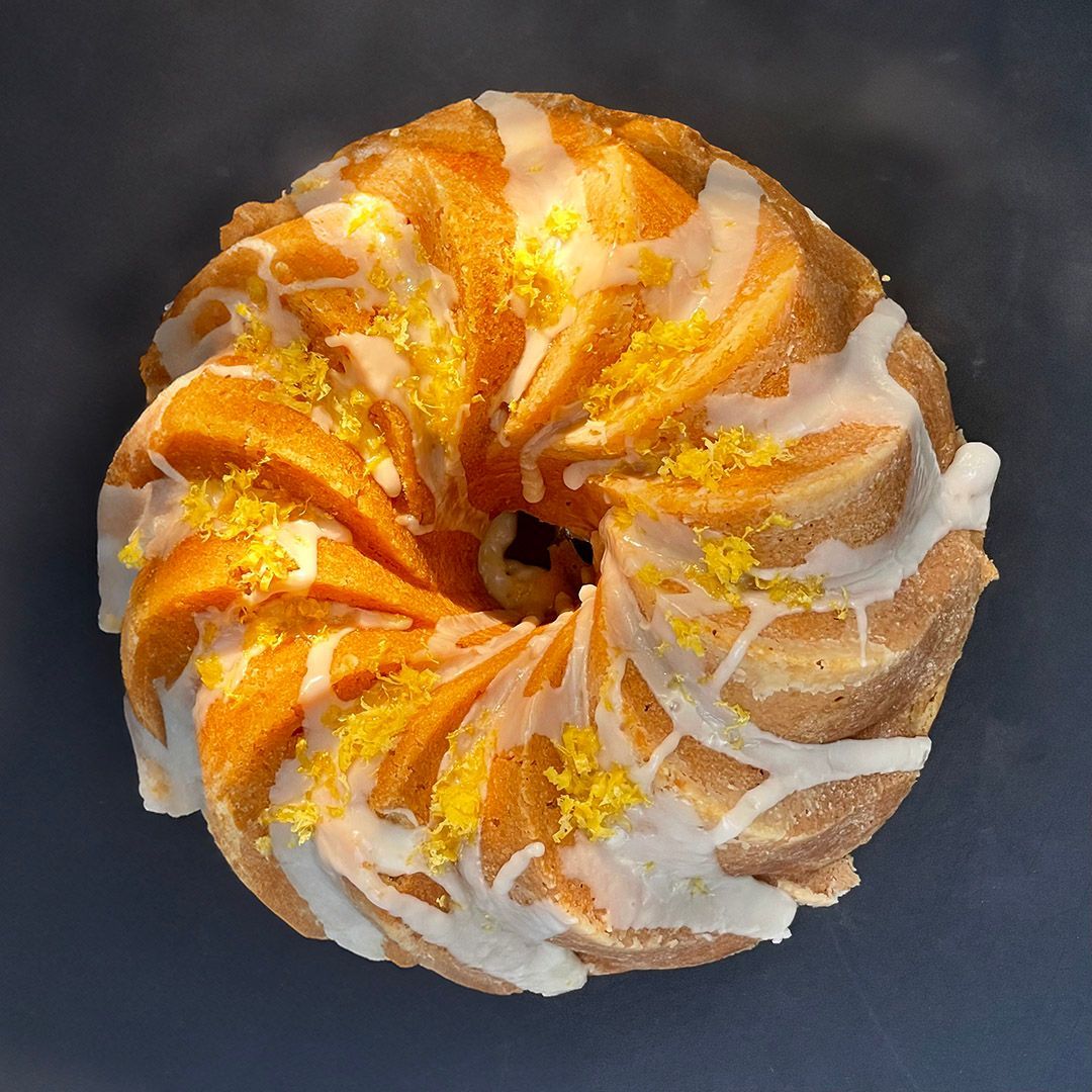 Lemon bundt cake with white icing and yellow zest.