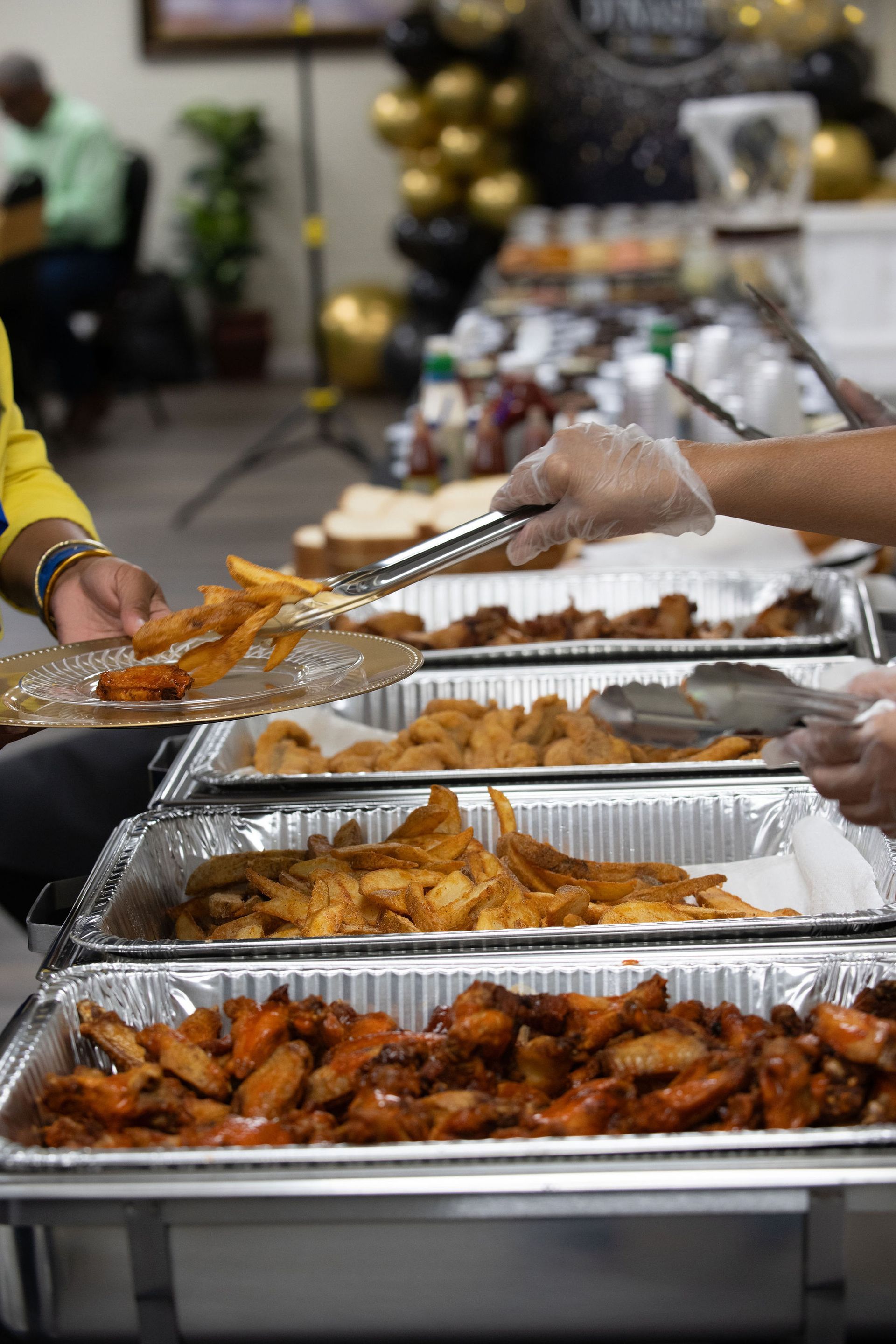 A group of people are serving food at a buffet table.