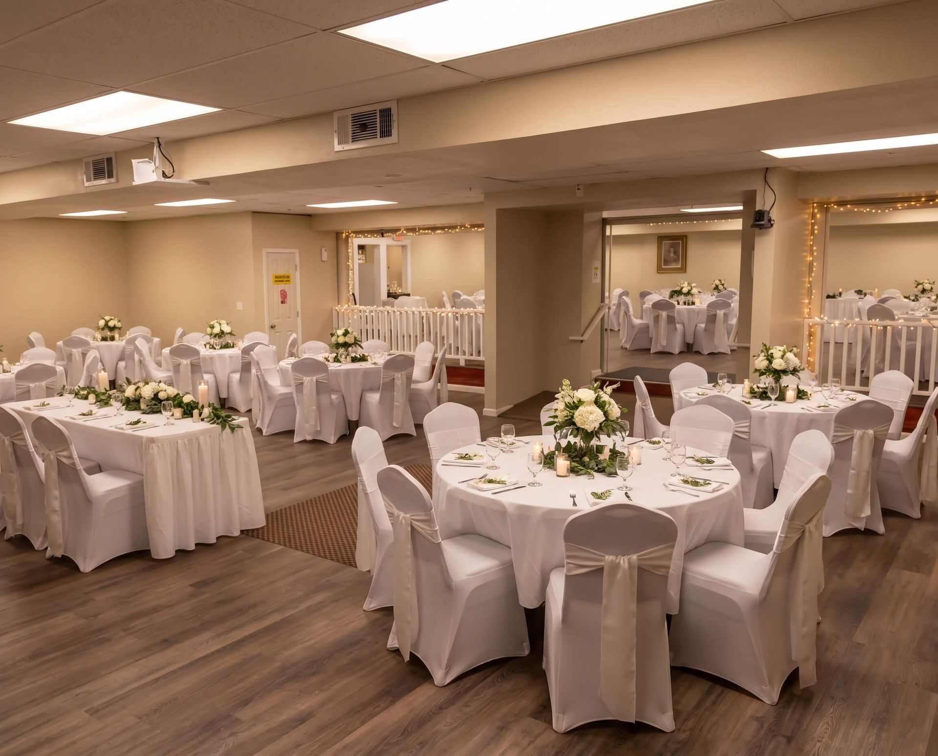 Decorated banquet hall with round tables and white chairs