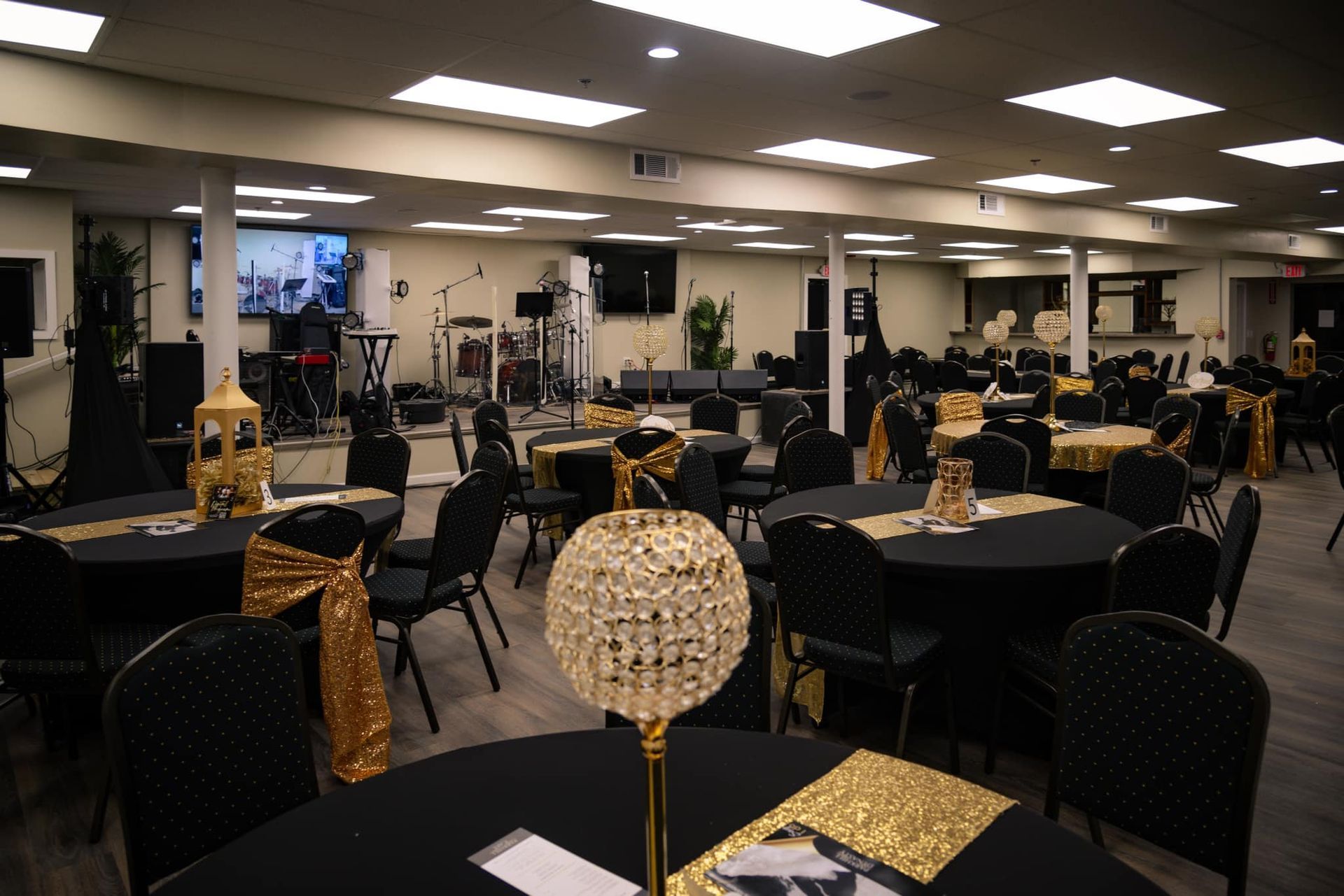 A large room with tables and chairs set up for a party.