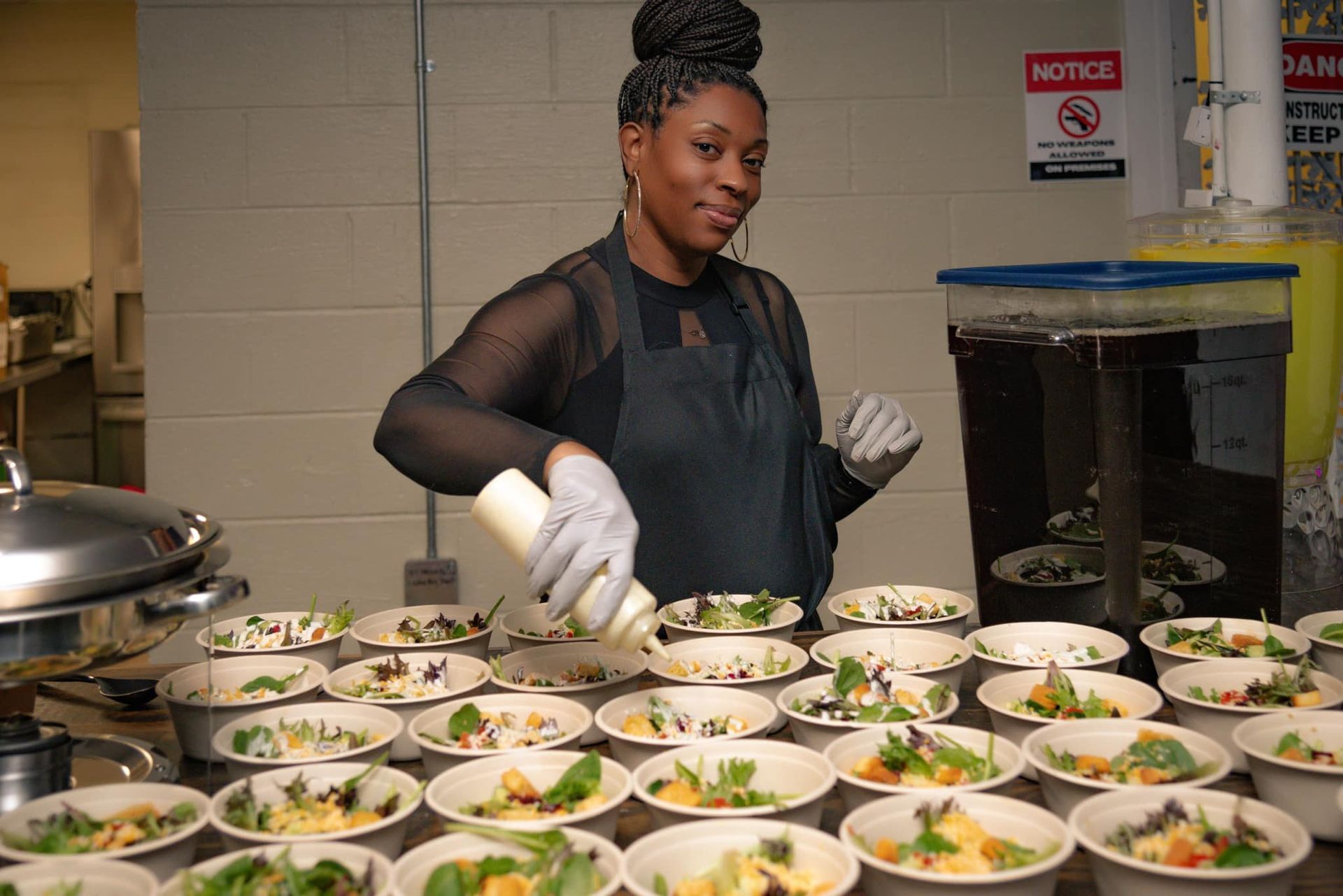 A woman is standing in front of a table filled with bowls of food.
