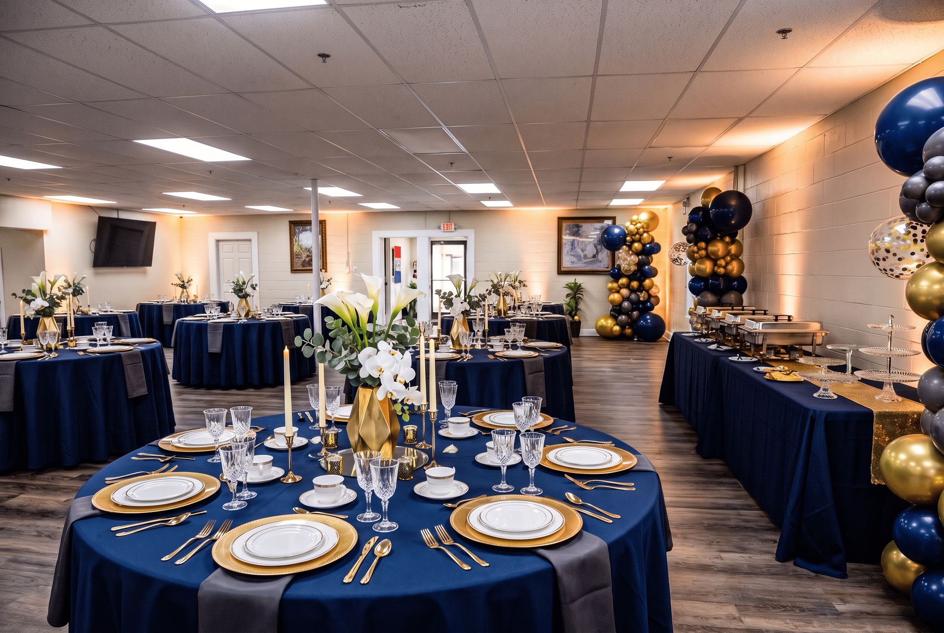 Banquet hall set with navy and gold table decor and floral centerpieces