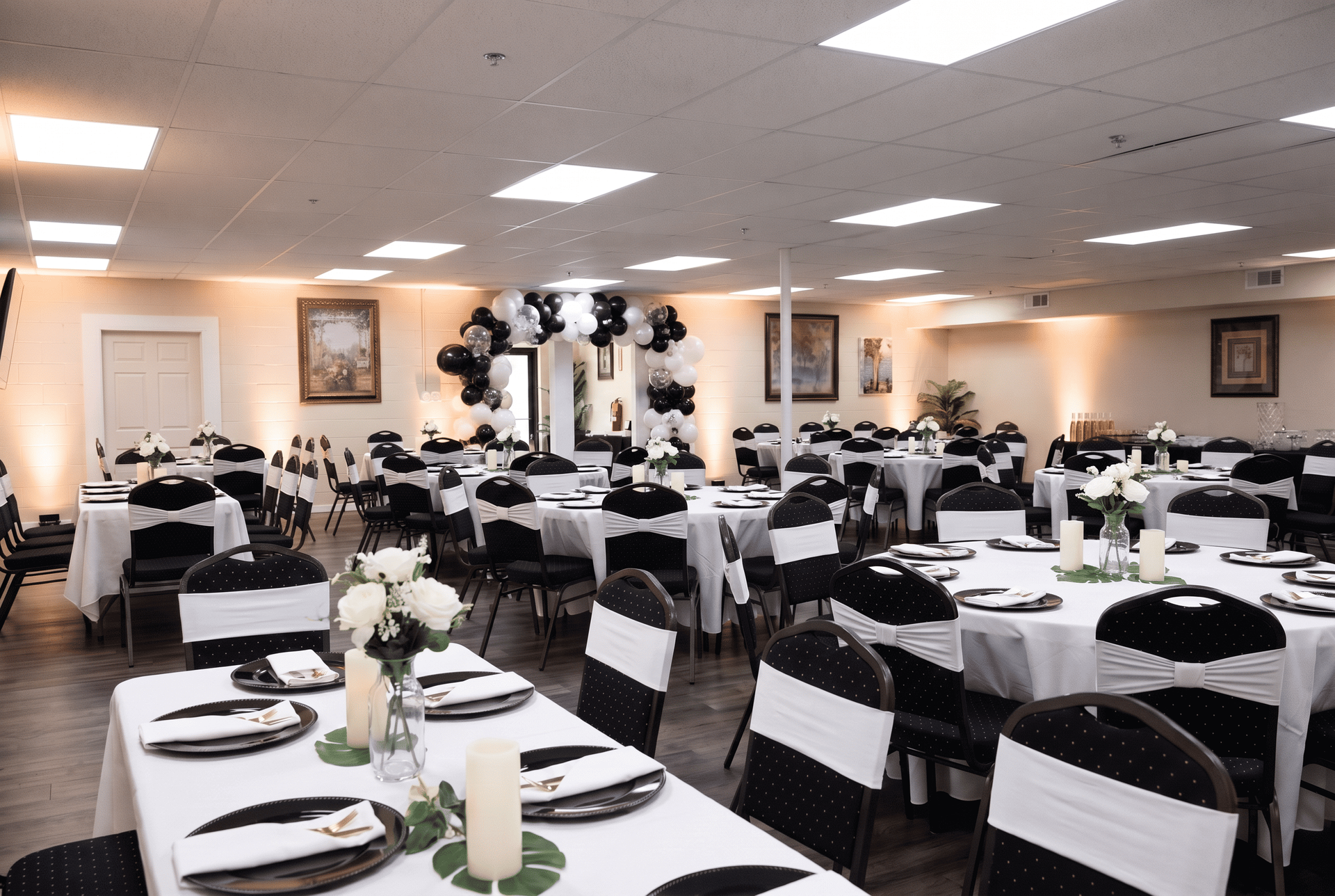 Banquet hall with round tables, black chairs, and white chair