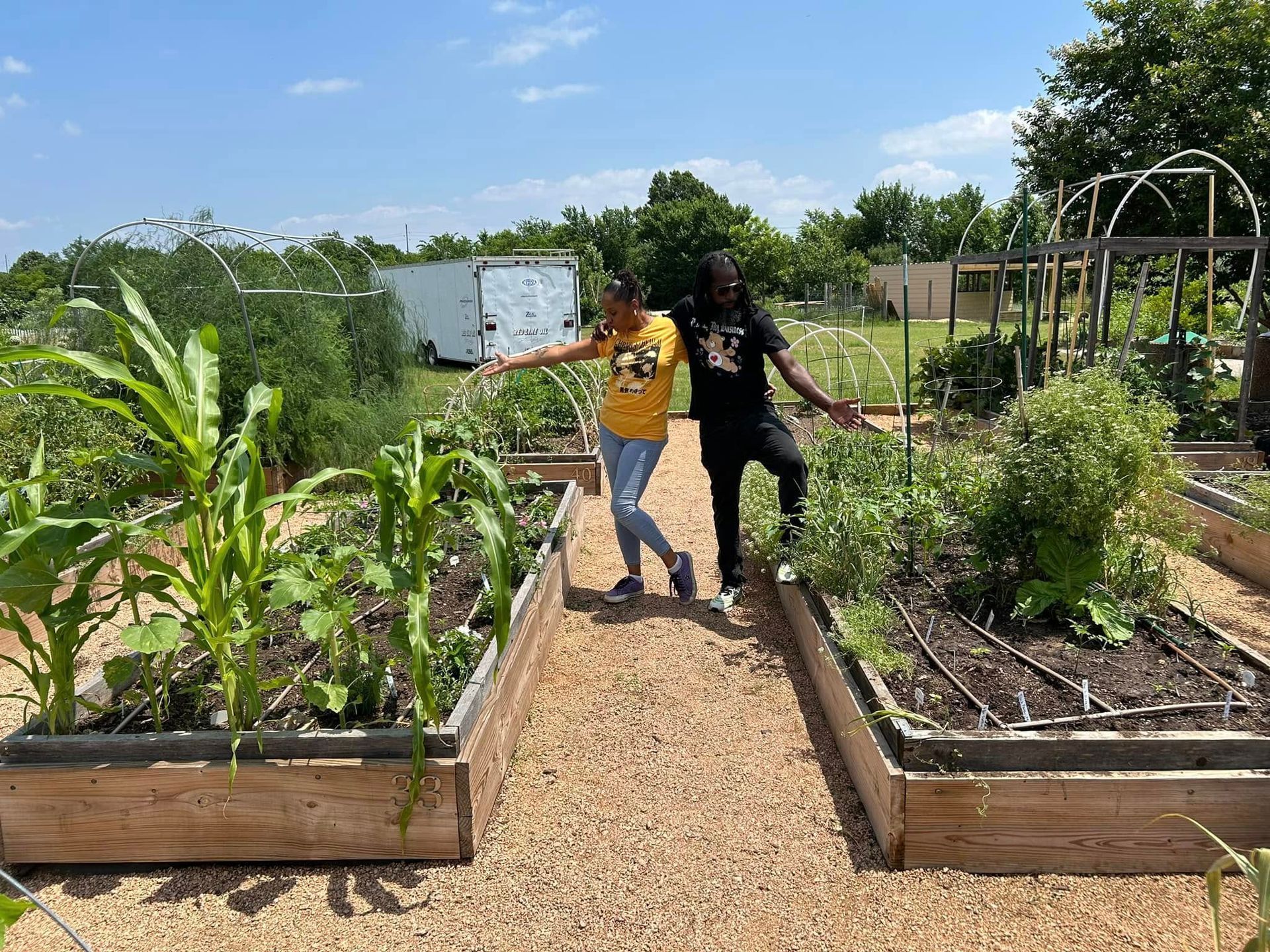 A man and a woman are standing next to each other in a garden.